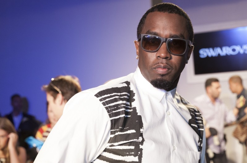 Diddy wearing a white shirt and dark sunglasses.
