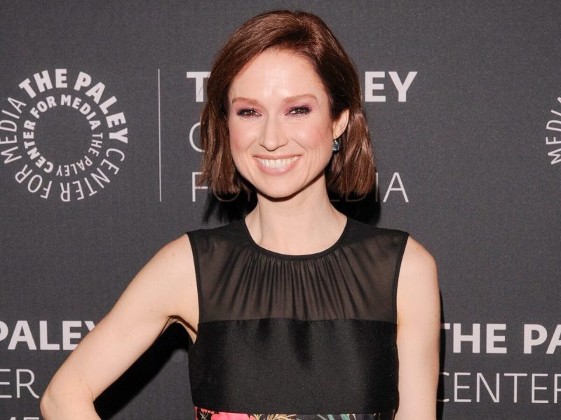 Ellie Kemper smiling and holding her hand on her hip