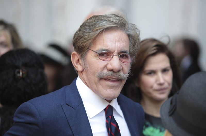 Geraldo Rivera in a crowd of people wearing a navy blue suit.