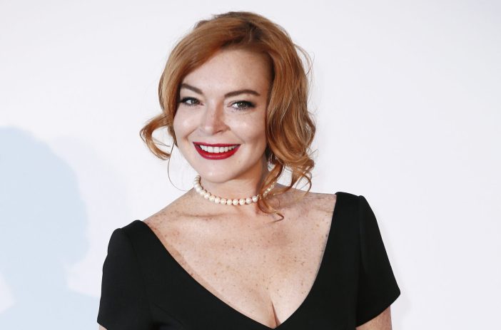 Lindsay Lohan wearing red lipstick and a white pearl necklace