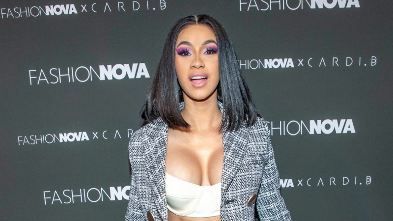 Cardi B wears a tweed blazer over a white crop top on the red carpet