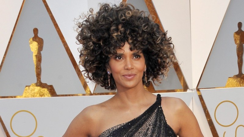 Halle Berry wears a black and gold gown on the red carpet