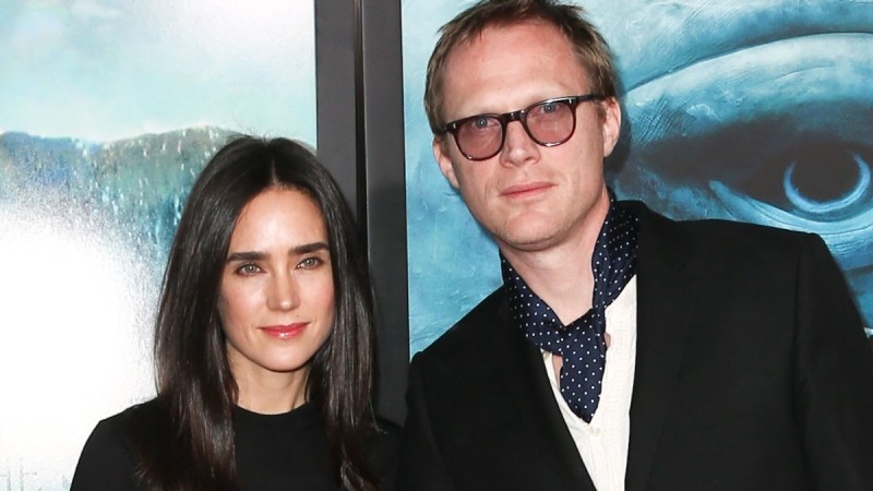 Jennifer Connelly, in a black dress, stands with husband Paul Bettany, in a black suit, on the red carpet