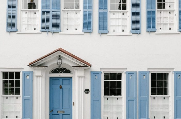 Image of two story home with blue shutters and blue door in Charleston, South Carolina.