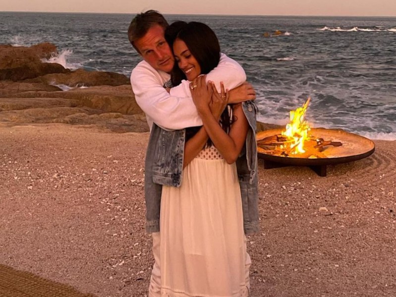 Rob Dyrdeck wraps his arms around his wife, Briyana on the beach in front of a bonfire