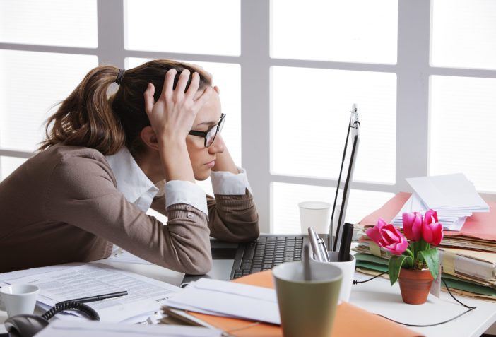 Image of a woman stressed out at work.