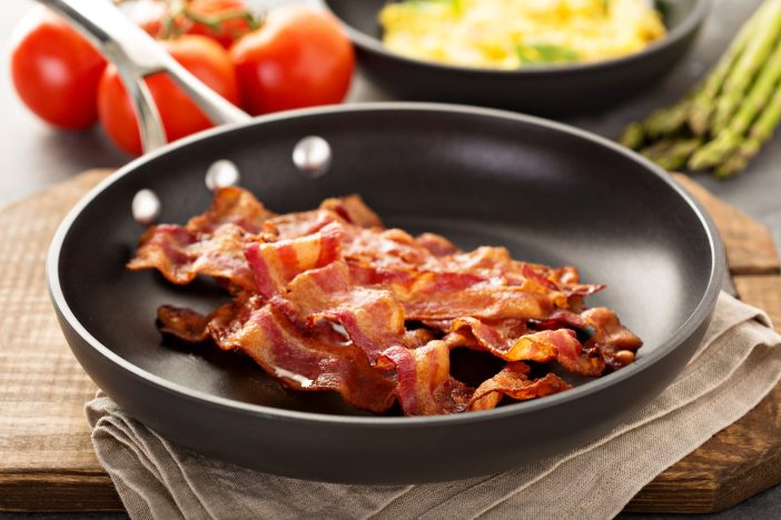 Image of bacon cooking in a skillet.