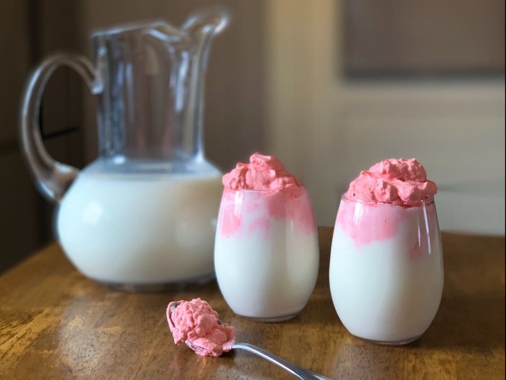 Two glasses of whipped strawberry milk.