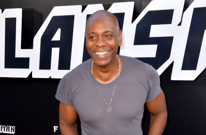Dave Chappelle smiling and wearing gray t-shirt