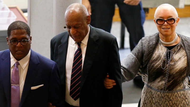 (Pool/Getty Images) Bill Cosby wearing a suit and tie and Camille Cosby smiling with sunglasses at 2017 trial