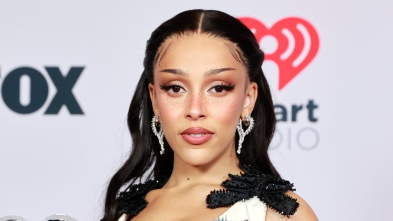 Doja Cat wears a white dress covered in cartoon cats on the red carpet
