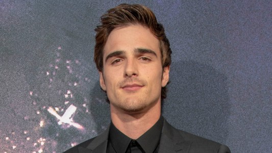 Jacob Elordi wears a dark suit with a black shirt on the red carpet