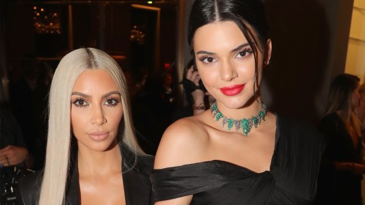 Kim Kardashian and Kendall Jenner, both dressed in black, pose for a photo