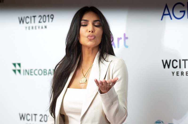 Kim Kardashian in all white, blowing a kiss