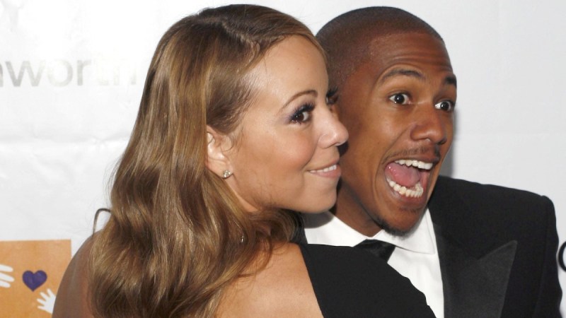Mariah Carey, in a black dress, cozies up to then-husband Nick Cannon, in a black tux, on the red carpet