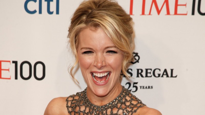 Megyn Kelly laughs while wearing a blue dress on the red carpet