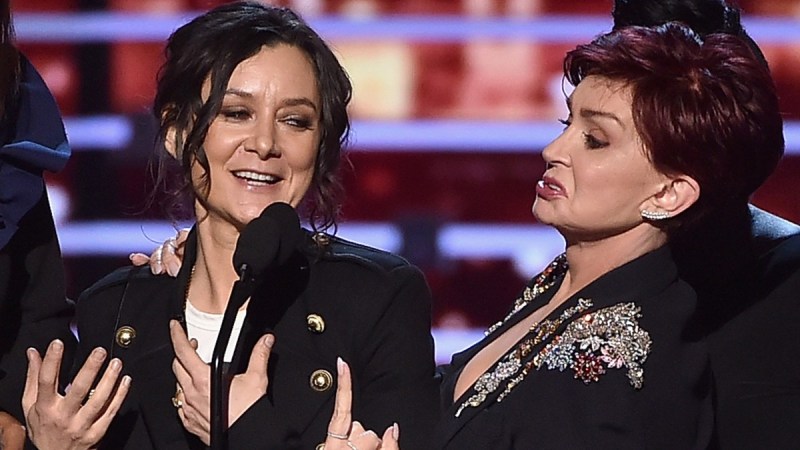 Sara Gilbert, left, and Sharon Osbourne stand together onstage as they accept an award