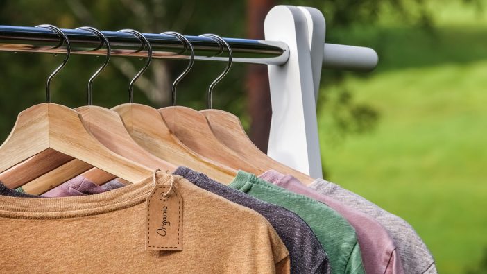 Image of clothes hung up on a rack outside.