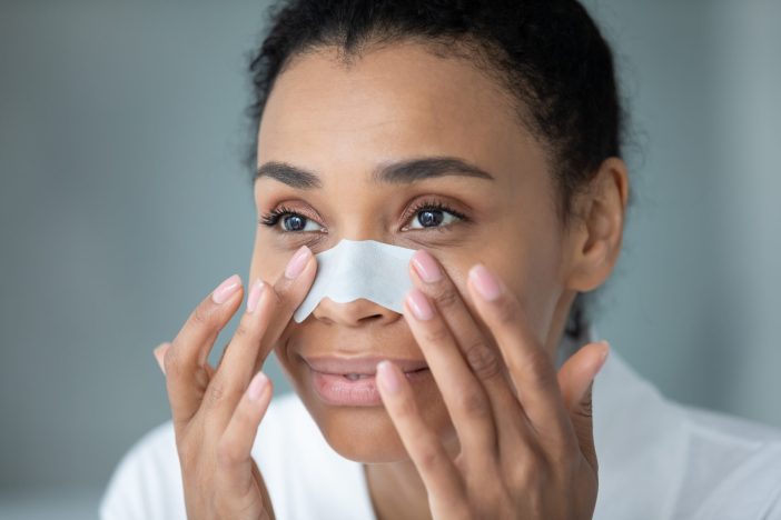 Image of a woman with a pore strip on her nose.