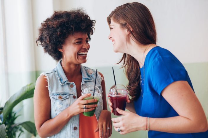 Image of two women chatting while drinking smoothies.