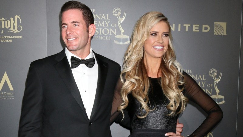 Tarek El Moussa and his now ex wife Christina Haack, both dressed in black formal wear, pose on the red carpet