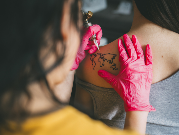 Woman tattooing other woman's shoulderblade