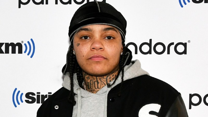 Young MA wears a black jacket over a gray hoodie on the red carpet