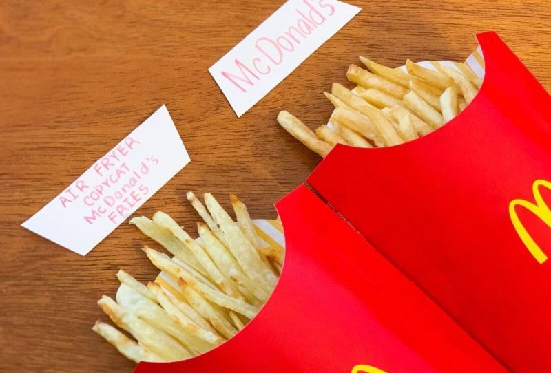 Our copycat McDonald's fries in a classic red McDonald's fry container next to the actual product.