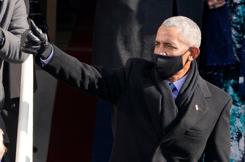 Barack Obama waving, wearing a mask.