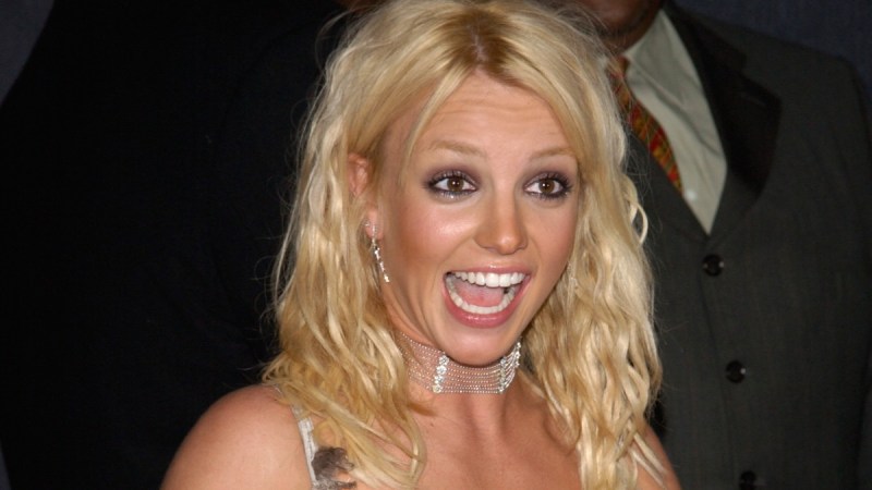 Britney Spears smiles at someone off camera while walking the red carpet