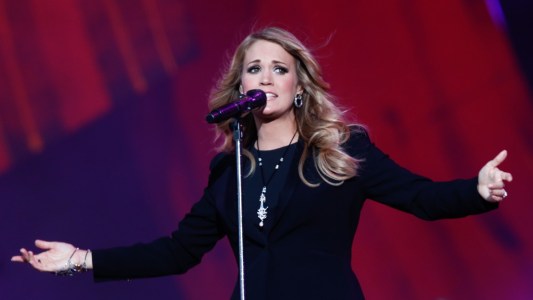 Carrie Underwood wears a black dress as she performs onstage