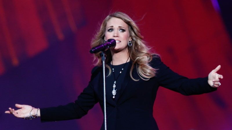 Carrie Underwood wears a black dress as she performs onstage