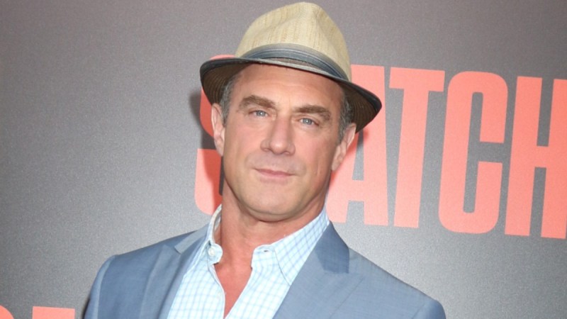Christopher Meloni wears a gray suit and a hat to a movie premiere
