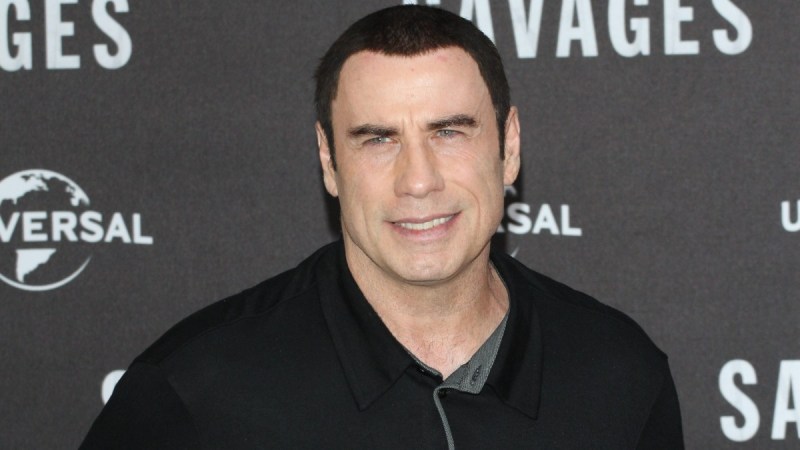 John Travolta wears a casual black jacket on the red carpet