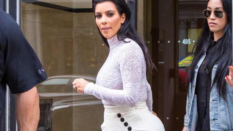 Kim Kardashian wears a lacy top and a long white skirt as she exits a shop