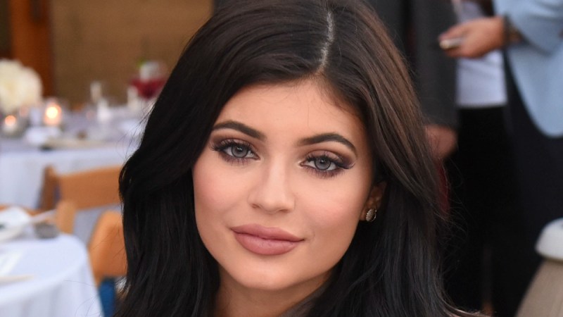 Kylie Jenner smiles demurely for the camera while attending a luncheon