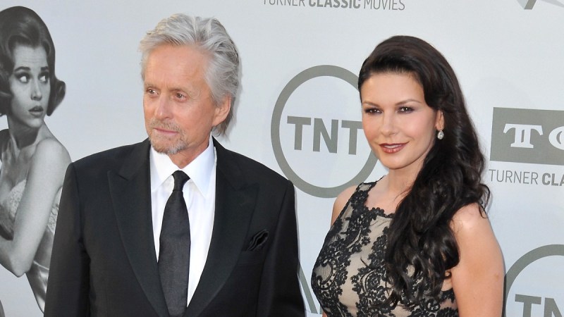 Michael Douglas, in a black suit, and Catherine Zeta-Jones, in a black dress, walk the red carpet