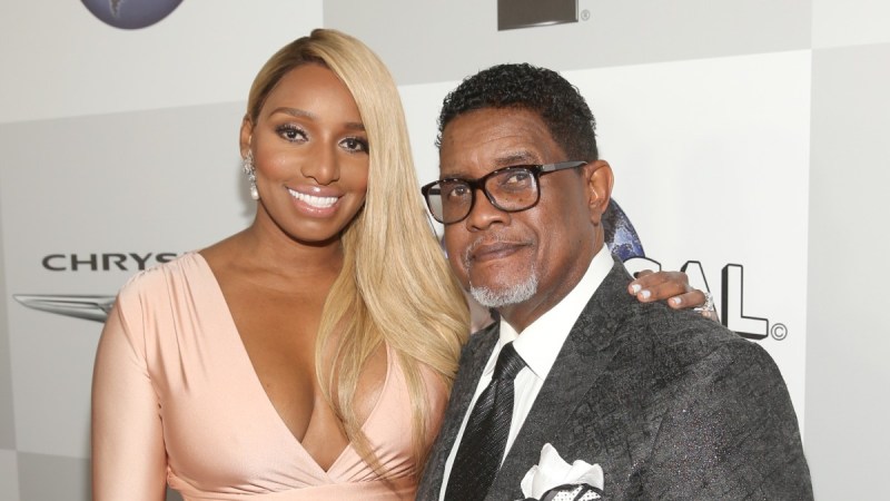 NeNe Leakes wears a peach colored gown and poses with husband Gregg, in a gray suit, on the red carpet
