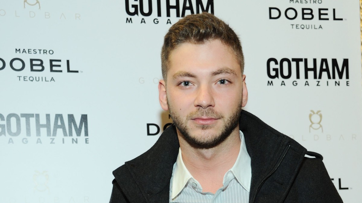 Serge Onik wears a dark coat over a light colored shirt on the red carpet