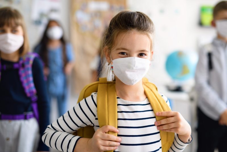 Image of little girl wearing a mask at school.