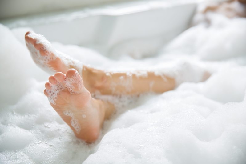Women's feet in a bathtub