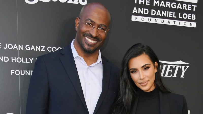 Van Jones, in a black suit, poses with Kim Kardashian, also in black, against a black background