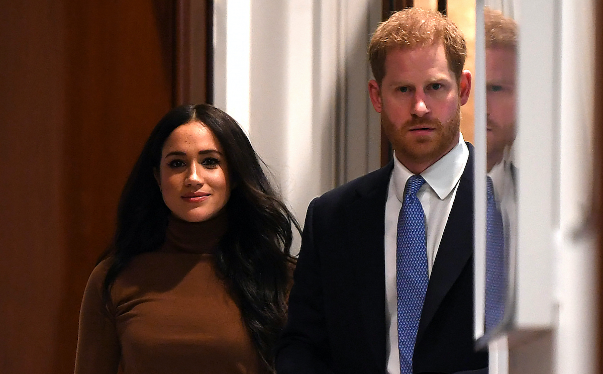 Meghan Markle in a brown sweater with Prince Harry in a blue suit