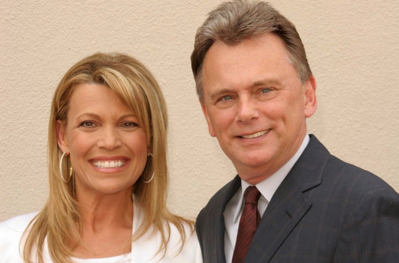 Vanna White on the left, standing with Pat Sajak at a charity event.