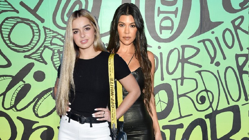 A cutout photo of Addison Rae wearing a black shirt and white pants over a photo of Kourtney Kardashian wearing a black dress against a green background
