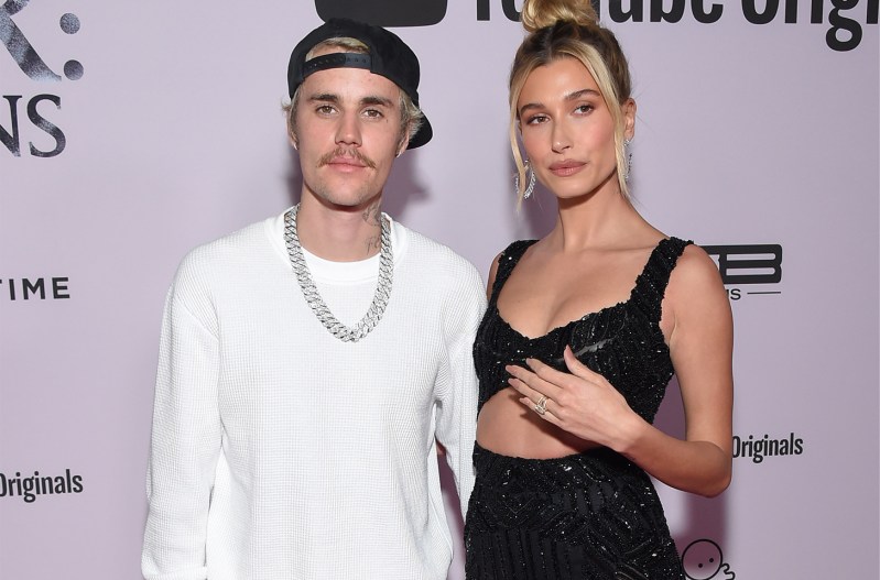 Hailey Bieber on the right, in a black dress, Juston Bieber on the right in a white tee shirt
