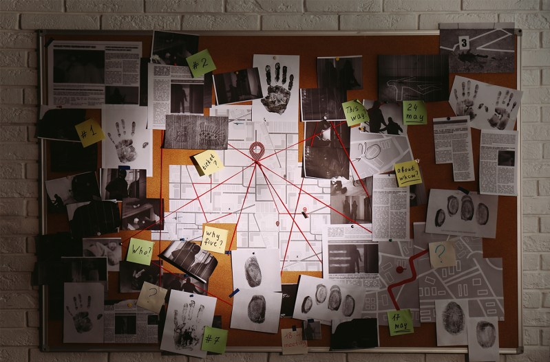A cork board with clues on it, trying to solve a crime.