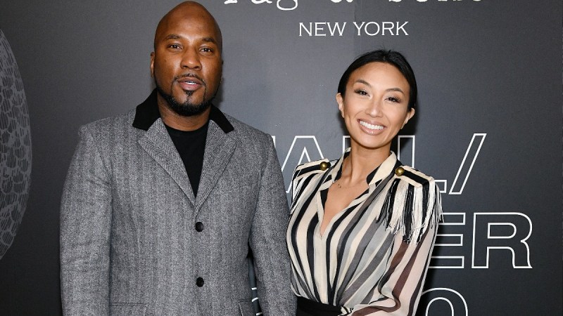 Jeezy, in a gray suit, poses with Jeannie Mai, in a stripped blouse, on the red carpet