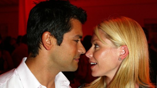 Mark Consuelos, in a white shirt, leans in close to Kelly Ripa