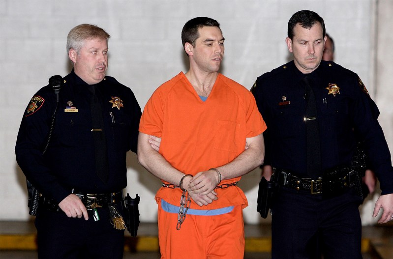Scott Peterson in shackles being led by police.